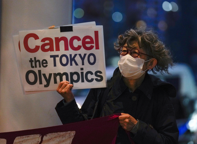 21일 일본 도쿄의 한 거리에서 한 시민이 도쿄 하계올림픽 취소를 요구하며 시위하고 있다. /EPA연합뉴스