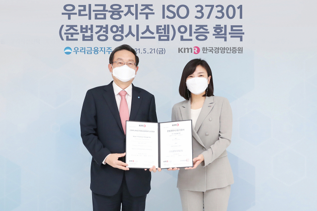 손태승(왼쪽) 우리금융그룹 회장과 황은주 한국경영인증원장이 지난 21일 서울 중구 우리금융그룹 본사에서 준법경영시스템 국제표준(ISO 37301) 공식 인증서를 함께 들어보이고 있다. 우리금융은 국내 금융권 중 처음으로 ISO 37301을 획득했다./사진 제공=우리금융