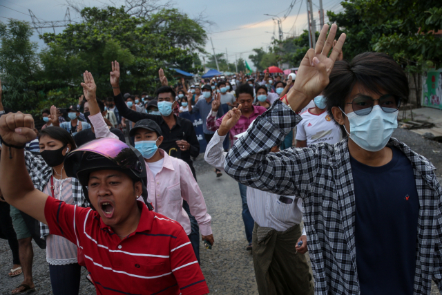 미얀마의 지방 도시 만달레이이서 지난 12일(현지시간) 시위대가 도로를 행진하며 군부 쿠데타에 대한 저항의 표시로 세 손가락 경례를 하고 있다. 이날은 쿠데타 발생 101일째에 해당한다. /EPA연합뉴스