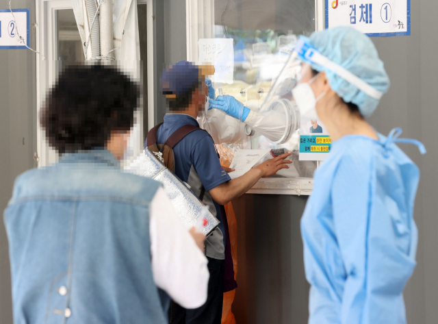 24일 오후 서울 중구 서울역 광장에 마련된 신종 코로나바이러스 감염증(코로나19) 임시 선별검사소에서 의료진이 검체를 채취하고 있다. /연합뉴스