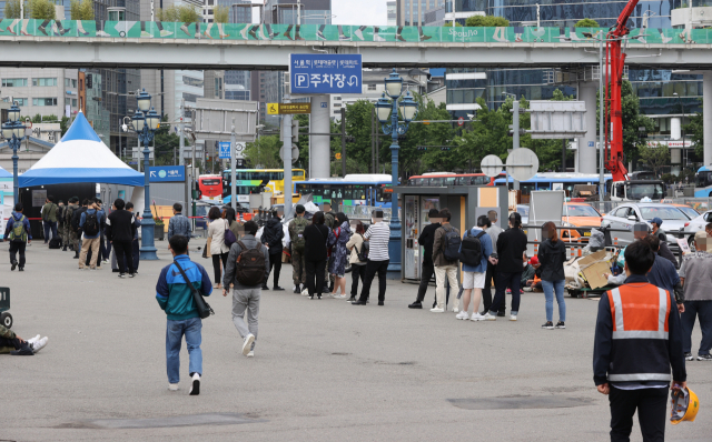 25일 오후 서울역 광장에 마련된 중구임시선별검사소에서 시민들이 신종 코로나바이러스 감염증(코로나19) 선별검사를 받기 위해 줄을 서있다. /연합뉴스