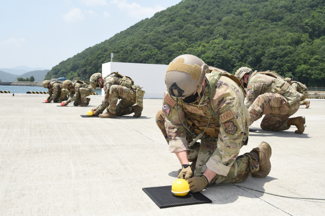 한미 공군 연합 폭발물 처리팀이 25일 해군 군수사령부 예한 탄약창에서 활주로에 산재된 불발자탄을 처리하기 위해 폭약을 설치하고 있다./사진제공=합참