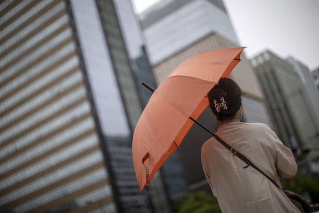 서울 세종로네거리에서 한 시민이 비가 내리는 지난 21일 우산을 쓴 채 보행신호를 기다리고 있다./ 연합뉴스
