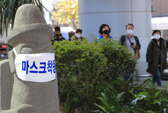 제주국제공항 입구에 세워진 돌하르방에 마스크가 씌어 있다. /연합뉴스