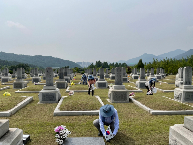 UST 교직원들이 대전현충원 독립유공자 제3묘역에서 태극기 꽂기와 주변 정화활동을 실시하고 있다. 사진제공=UST