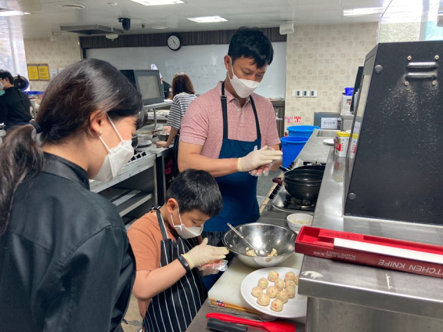 와이즈유 영산대 K-food조리전공이 가족 단위 교육생들에게 불고기 떡볶이 등 요리법 교육 재능기부를 실시하고 있다./사진제공=영산대