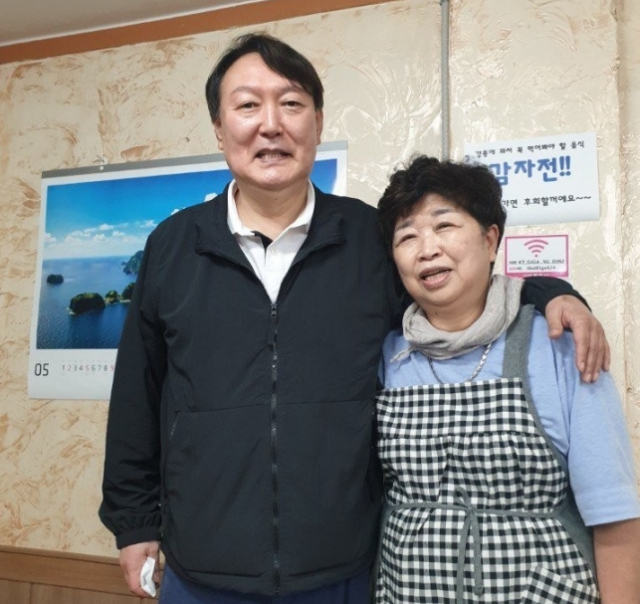 윤석열 전 검찰총장이 지난달 29일 강원 강릉시 강릉중앙시장 인근 감자바우 식당에서 음식점 사장과 기념사진을 찍고 있다./연합뉴스