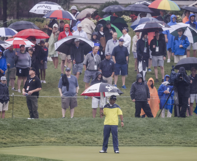 메모리얼 모너먼트 첫날 마쓰야마 히데키가 18번 홀 그린에서 우산을 들고 퍼트 라인을 살펴보고 있다. 이날 경기는 악천후로 일부 선수들이 18홀을 마치지 못한 가운데 다음날로 연기됐다. /더블린=EPA연합뉴스