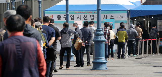 4일 서울역 광장에 설치된 중구 코로나19 임시선별검사소에서 검사를 받으려는 시민들이 줄을 서 대기하고 있다./연합뉴스