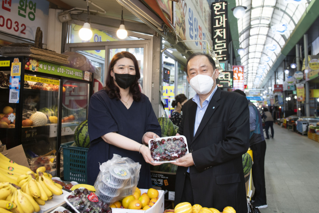 김호빈(오른쪽) 한국중부발전 사장이 7일 보령 전통시장을 방문해 과일을 산 후 기념촬영을 하고 있다.