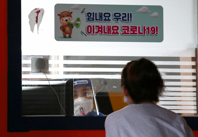 보건소 선별진료소에서 의료진이 코로나19 검사 접수를 하고 있다./연합뉴스