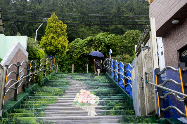 흰여울마을에서 산복도로로 연결되는 계단을 한 주민이 오르고 있다. 부산의 대표 판자촌인 흰여울마을은 산동네가 아니라 산 아래 절벽에 자리하고 있다.
