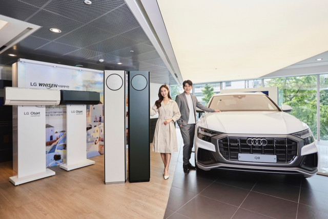 모델들이 서울시 강남구 소재 도산대로 아우디 도산대로 쇼룸에서 LG 휘센 타워 에어컨(왼쪽)과 아우디 Q8 차량을 소개하고 있다./사진제공=LG전자