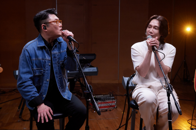 가수 김현철(왼쪽)과 듀오 1415의 멤버 주성근이 지난 달 24일 KBS ‘여의도동 녹음실’ 녹음 현장에서 함께 노래하고 있다. /사진 제공=KBS