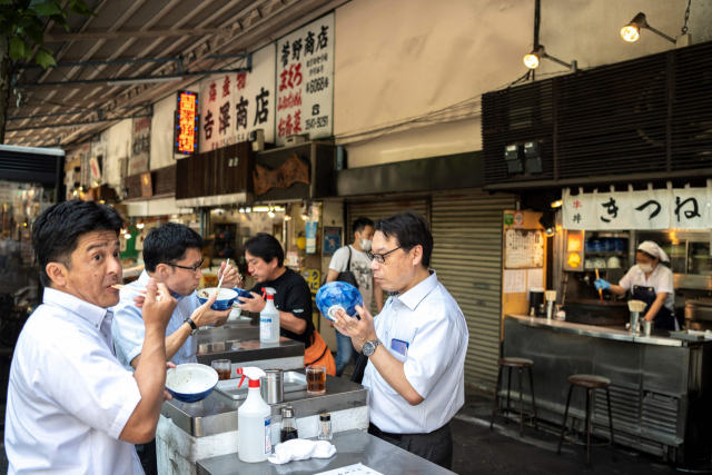 일본 도쿄의 한 상점가에서 8일 시민들이 아침 식사를 하고 있다. /AFP연합뉴스