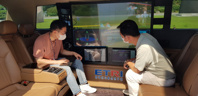 ETRI가 개발한 자율주행차 ‘오토비’에 탑승한 ETRI 연구진이 실시간 차량 정보 등을 살펴보고 있다. 사진제공=ETRI