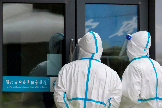 지난 1월 29일 WHO 연구원들이 신종 코로나바이러스(코로나19) 기원에 대한 방문 연구를 진행하고 있는 중국 후베이성 우한의 한 병원 앞에서 의료진들이 방역복을 입고 서있다. /로이터연합뉴스