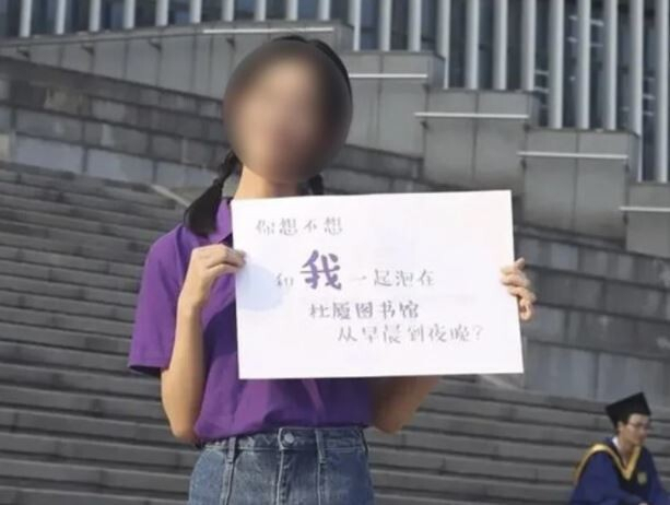 중국 난징대의 한 여학생이 “나랑 하루종일 도서관에 같이 있을래”라는 문구를 들고 있다./ 웨이보 캡처