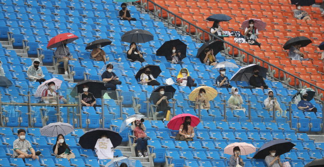지난 10일 오후 서울 잠실야구장에서 열린 2021 프로야구 NC와 LG의 경기. 빗속 경기를 관람온 관중들이 우산을 들고 경기를 지켜보고 있다./연합뉴스