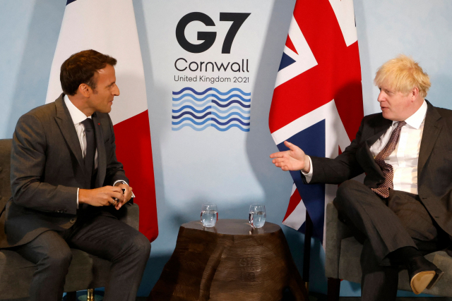 요 7개국(G7) 정상회의에 참석한 보리스 존슨(오른쪽) 영국 총리와 에마뉘엘 마크롱 프랑스 대통령이 12일(현지시간) 콘월주 카비스 베이에서 양자 회담을 하고 있다. /AFP연합뉴스