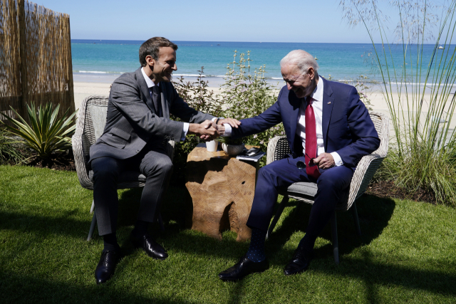조 바이든(오른쪽) 미국 대통령과 에마뉘엘 마크롱 프랑스 대통령이 12일(현지 시간) 양자회담에서 손을 맞잡고 밝게 웃고 있다. /AP연합뉴스
