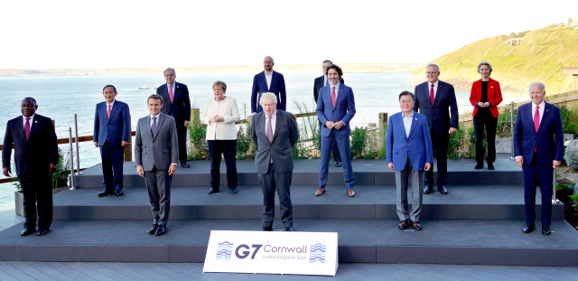 주요 7개국(G7) 정상회의가 영국 콘월에서 열린 가운데 문재인 대통령이 12일(현지 시간) 카비스베이의 회의장 앞에서 G7 및 초청국 정상들과 단체 사진을 찍고 있다. 시릴 라마포사(앞줄 왼쪽부터) 남아프리카공화국 대통령, 에마뉘엘 마크롱 프랑스 대통령, 보리스 존슨 영국 총리, 문 대통령, 조 바이든 미국 대통령, 스가 요시히데(둘째 줄 왼쪽부터) 일본 총리, 앙겔라 메르켈 독일 총리, 쥐스탱 트뤼도 캐나다 총리, 스콧 모리슨 호주 총리, 안토니우 구테흐스(셋째 줄 왼쪽부터) 유엔 사무총장, 샤를 미셸 유럽연합(EU) 정상회의 상임의장, 마리오 드라기 이탈리아 총리, 우르줄라 폰데어라이엔 EU 집행위원장. /연합뉴스