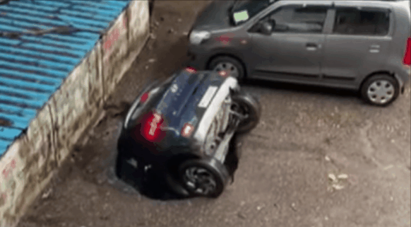 지난 13일 인도 뭄바이의 한 마을 주차장에서 주차된 자동차가 싱크홀에 빠지는 모습./출처=유튜브