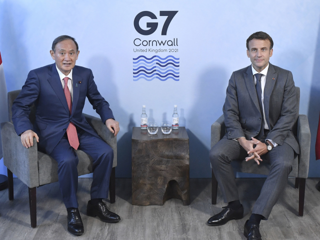 영국 콘월에서 열린 주요 7개국(G7) 정상회의에 참석 중인 스가 요시히데(왼쪽) 일본 총리와 에마뉘엘 마크롱 프랑스 대통령이 12일 오후(현지시간) 양자 회담에 앞서 사진 촬영에 임하는 모습. /교도연합뉴스