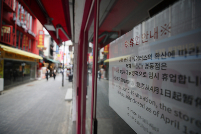 지난 달 23일 서울 명동의 한 가게에 코로나19로 인한 잠정휴점 관련 안내문이 붙어 있다./연합뉴스