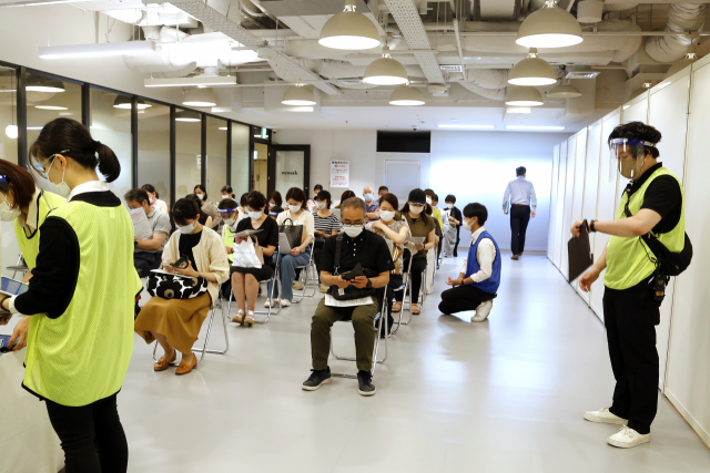 일본 수도 도쿄의 공유오피스 '위워크'에 마련된 코로나19 백신 접종소에서 15일(현지시간) 의료계 종사자들이 모더나사의 코로나19 백신을 맞기 위해 차례를 기다리고 있다. /AP연합뉴스