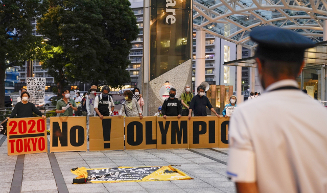 일본 도쿄에 있는 도쿄올림픽조직위원회의 입주 빌딩 주변에서 지난달 18일 시위대가 모여 올림픽 개최 반대를 촉구하고 있다. /연합뉴스