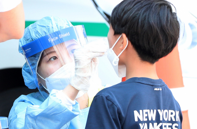 지난 21일 강원 춘천시보건소에 마련된 선별진료소에서 어린이가 신종 코로나바이러스 감염증(코로나19) 검사를 받고 있다./연합뉴스