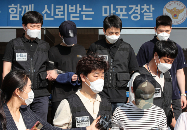 오피스텔에서 친구를 감금해 살해한 혐의를 받는 피의자 안모·김모 씨가 22일 오전 검찰로 송치되기 위해 서울 마포구 마포경찰서를 나서고 있다./연합뉴스