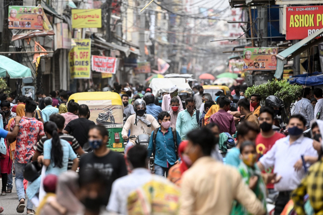 13일(현지시간) 인도 뉴델리 인근 구루그람(옛 구르가온)의 한 시장에서 시민들이 장을 보고 있다. 지난달 초 41만 명을 넘어섰던 인도의 신종 코로나바이러스 감염증(코로나19) 일일 신규 확진자 수가 7만 명대로 줄어들자 수도 뉴델리 등에서는 이날부터 식당, 쇼핑몰, 상점 등의 영업이 거의 정상화됐다. /AFP연합뉴스