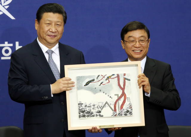 지난 2014년 시진핑(왼쪽) 중국 국가주석이 서울대를 방문한 자리에서 오연천 당시 서울대 총장으로부터 김병종 화백의 그림을 선물받고 기념 촬영을 하고 있다. /연합뉴스