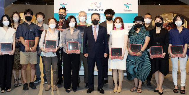 박성호(앞줄 왼쪽 다섯번째) 하나은행장이 지난 22일 잠실 롯데월드몰에서 ‘Korean Eye 2020’ 프로젝트의 서울 전시회에 참여한 작가들과 함께 전시회 개최를 축하하고 있다./사진 제공=하나은행