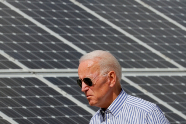 조 바이든 미국 대통령이 대선 후보였던 지난 2019년 6월 당시 뉴햄프셔주 플리머스의 재생에너지 단지를 방문해 태양광발전 패널 앞을 걸어가고 있다./로이터 연합뉴스