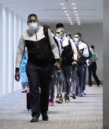 도쿄 올림픽에 참가하기 위해 일본에 도착한 아프리카 국가 우간다 선수단이 20일 새벽 일본 수도권 관문인 나리타(成田) 국제공항에서 이동하고 있다. /교도연합뉴스