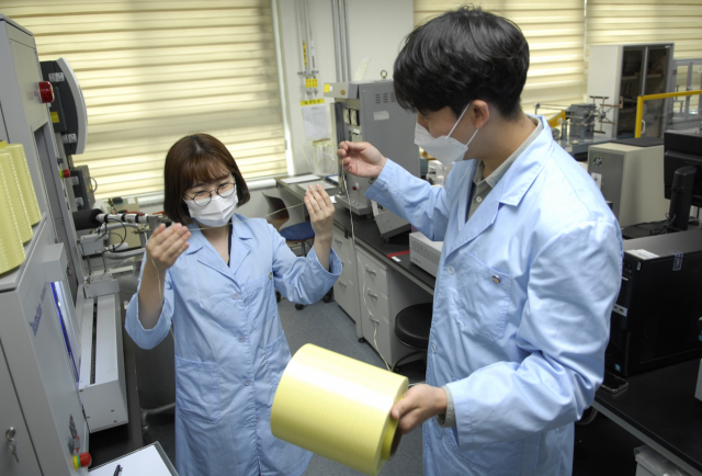코오롱인더스트리 연구원들이 아라미드 섬유인 헤라크론 제품을 살펴보고 있다./사진 제공=코오롱