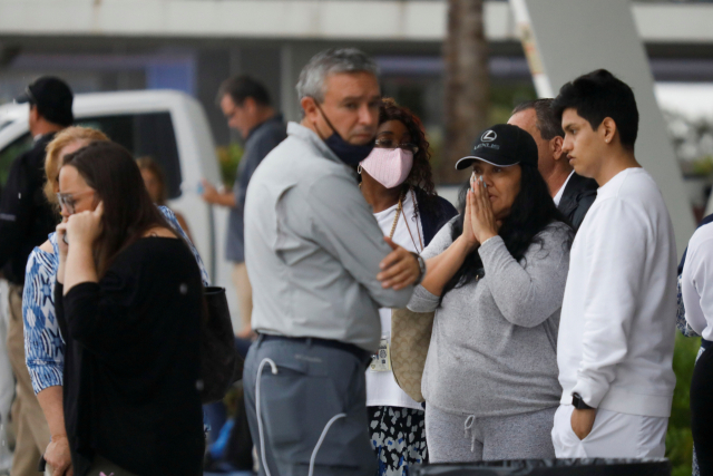 플로리다주의 아파트 붕괴사고 현장과 가까운 서프사이드 주민센터에 사람들이 망연자실한 표정으로 서 있다./로이터연합뉴스