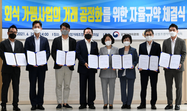 조성욱 공정거래위원장이 25일 오후 서울 중구 한국공정거래조정원 대회의실에서 열린 외식 가맹사업의 거래 공정화를 위한 자율규약 체결식에서 서명을 마친 뒤 참가자들과 기념촬영을 하고 있다. 왼쪽부터 맘스터치앤컴퍼니 김동전 대표, 놀부 안세진 대표, 롯데지알에스 차우철 대표, 글로벌프랜차이즈협의회 이승창 회장, 조성욱 공정거래위원장, 제너시스비비큐 윤경주 대표, 투썸플레이스 이영상 대표, 이랜드이츠 김영 운영본부장./권욱 기자