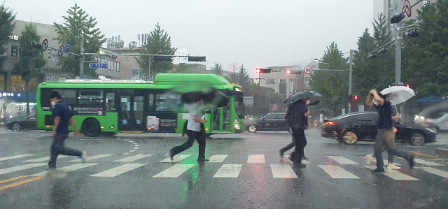 소나기가 내린 27일 오후 서울 은평구 불광역사거리 인근에서 시민들이 비를 피해 뛰어가고 있다. /연합뉴스