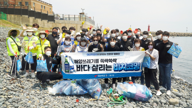 부산 해운대 청사포에서 대선주조 임직원과 시민들이 해안 정화 활동 '비치코밍'을 진행했다./사진제공=대선주조