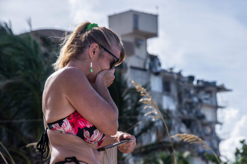 지난 24일 붕괴한 미국 플로리다주 마이애미 비치 북쪽 서프사이드의 12층 아파트 붕괴 현장에서 한 여성이 슬퍼하고 있다. /AFP연합뉴스