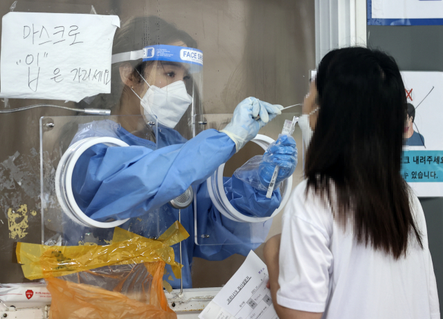 국내 신종 코로나바이러스 감염증(코로나19) 확산세가 지속하면서 신규 확진자 수 700명대 중반을 기록한 4일 오전 서울역에 설치된 임시선별검사소에서 시민이 검사를 받고 있다. /연합뉴스