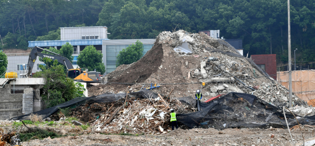 지난달 14일 오전 광주 동구 학동4구역 재개발 철거 건물 붕괴 참사 현장에서 공사 관계자들이 잔해물을 치우고 있다. /연합뉴스