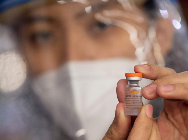 지난달 14일(현지 시간) 필리핀에서 한 의료진이 중국산 백신인 시노백 백신을 들고 있다./AFP연합뉴스