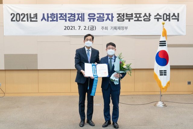 지난 2일 제3회 대한민국 사회적경제박람회 개막식이 열린 광주 김대중컨벤션센터에서 한훈 기획재정부 차관보(왼쪽)가 금종익 한국예탁결제원 정보보호최고책임자에게 '2021년 사회적경제 활성화 유공 정부포상'으로 국무총리 표창을 수여한 뒤 기념 촬영을 하고 있다./사진제공=예탁결제원