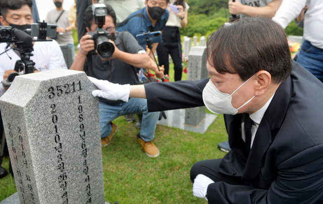 윤석열 전 검찰총장이 6일 오전 대전 유성구 국립대전현충원 천안함 46용사 묘역을 찾아 묘비를 어루만지고 있다. /연합뉴스