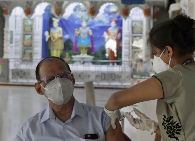 인도 서부 뭄바이의 한 사원에 마련된 신종 코로나바이러스 감염증(코로나19) 백신 접종소에서 의료진이 한 남성에게 백신을 접종하고 있다. /AP연합뉴스